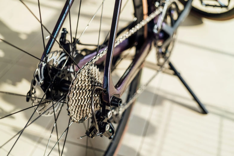 the spokes and gears of a bicycle parked on the sidewalk