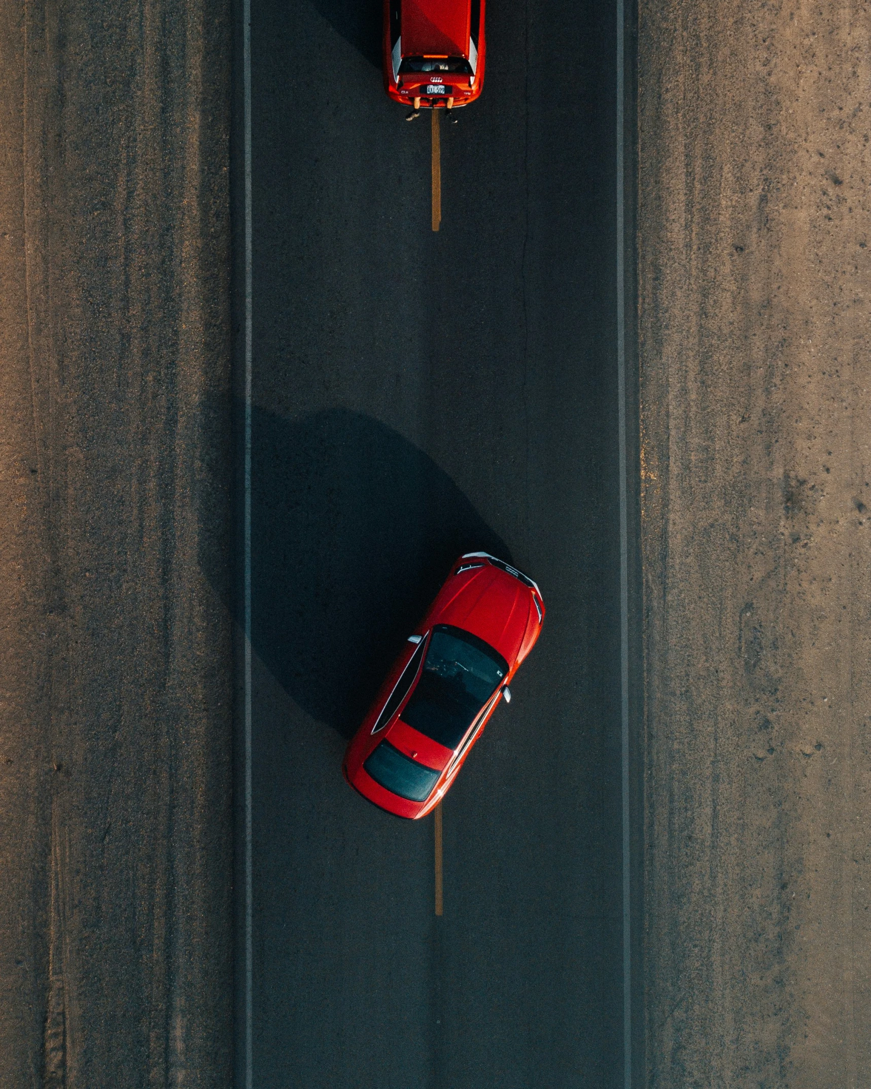 two red sports cars are seen overhead from above