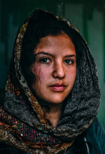 a woman in a scarf stares straight ahead