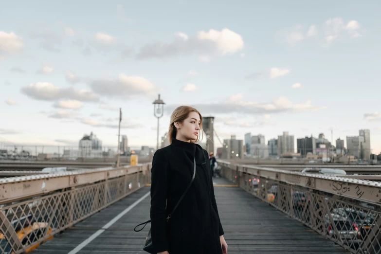 a young lady on a bridge with skyline in the background