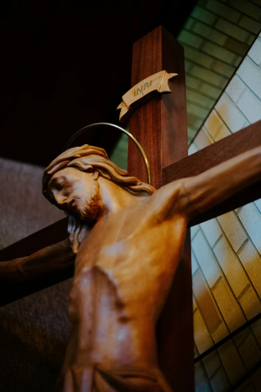 the image shows a bronze crucifix with a sign on it