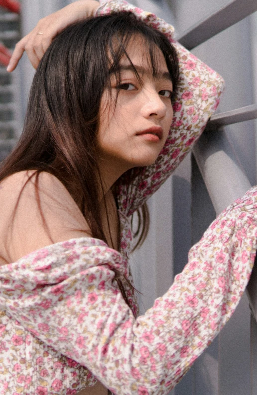 a young woman in floral print top looking down