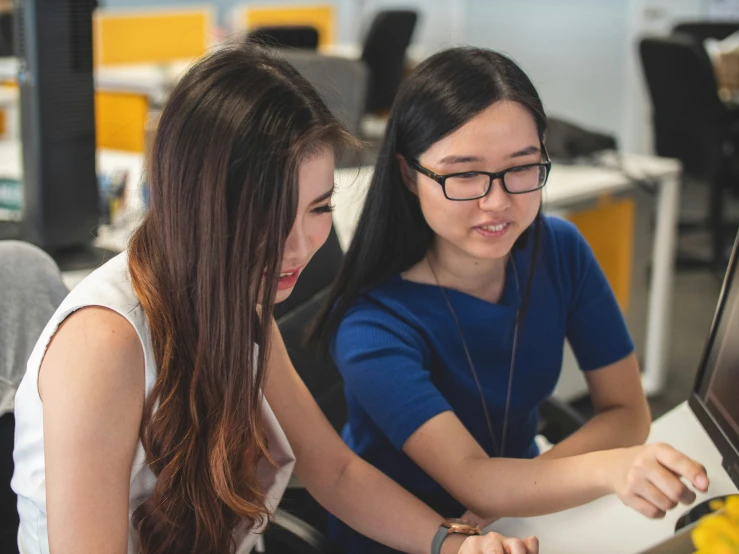 two young women working on an electronic device