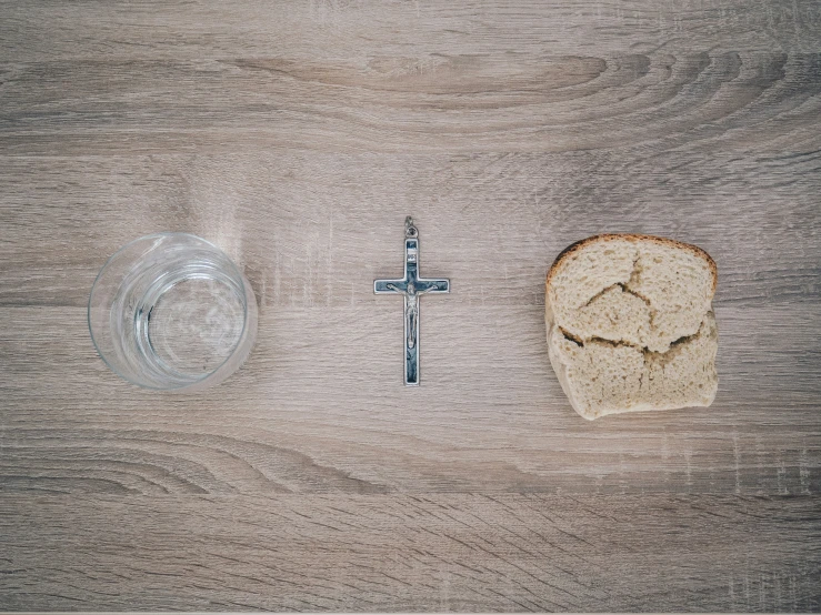 a cross and piece of bread laying on the table