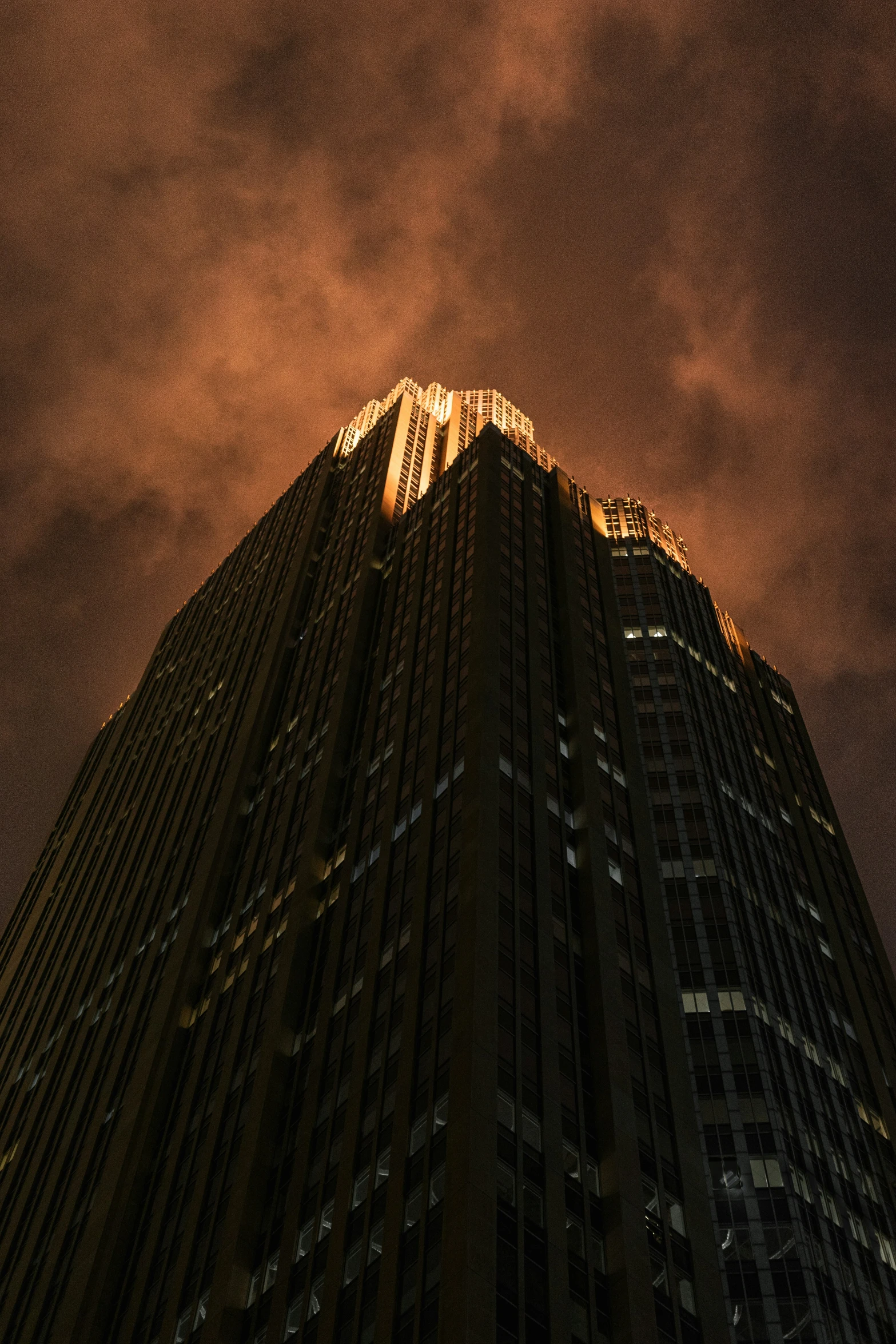 a high building with the dark and bright lights from the base of it