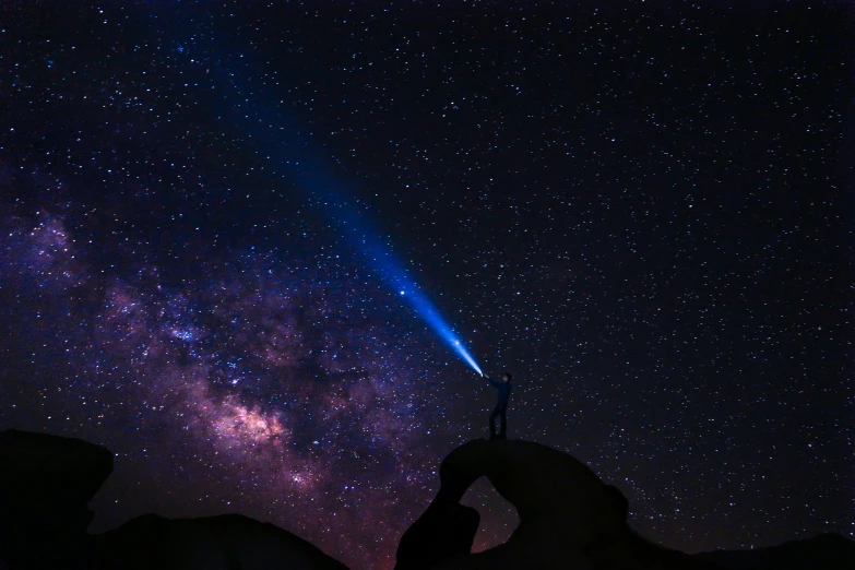 a pair of hands holding an object beneath the starry night sky