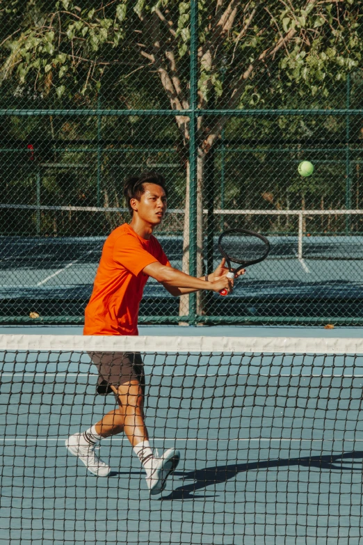 a young man is playing tennis on the court