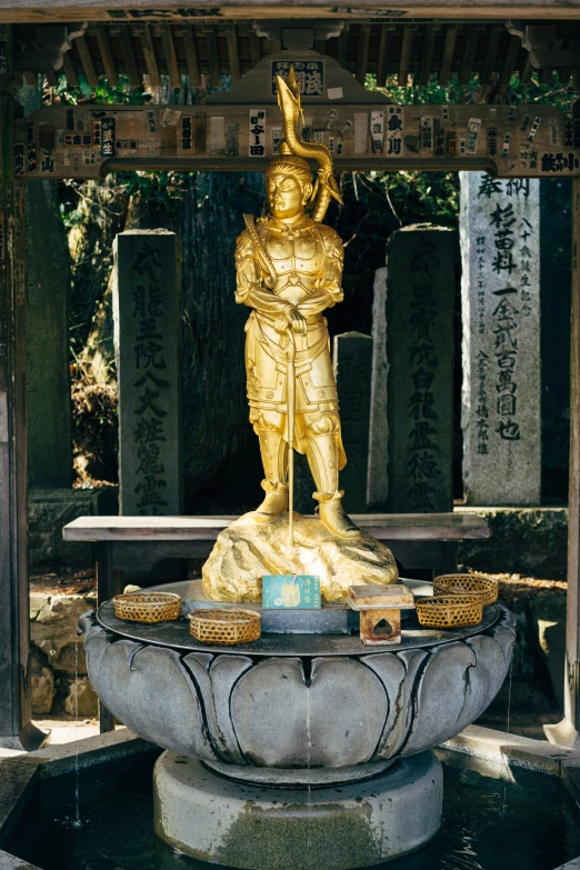 a large statue sits next to an array of rocks