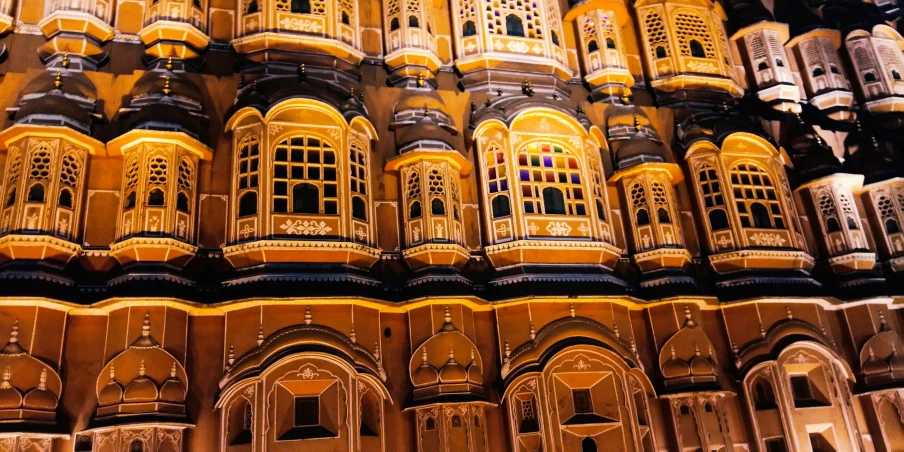 a large decorative building is lit up at night