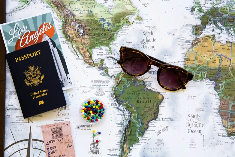 an american passport, pair of sunglasses, and candy in front of the map