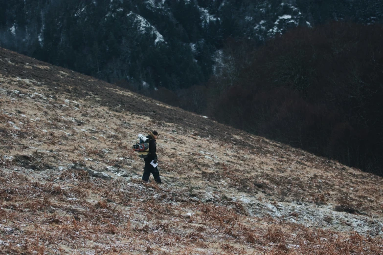 a man on a hill holding a camera