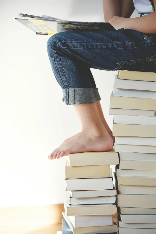 a person sitting on top of books as if reading