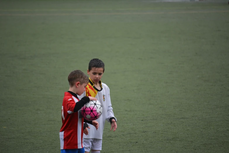 a  and girl are playing soccer on a field