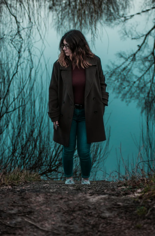 the woman is posing for a pograph with trees in the background