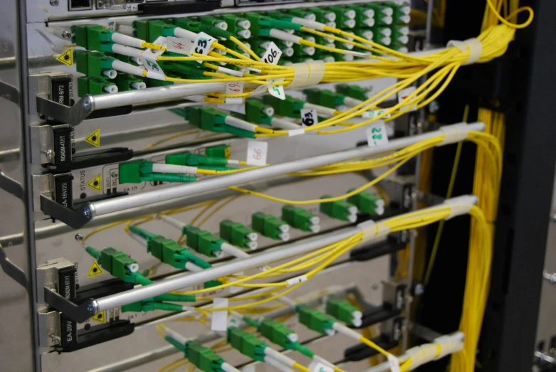 a rack of green and yellow wires connected to a computer