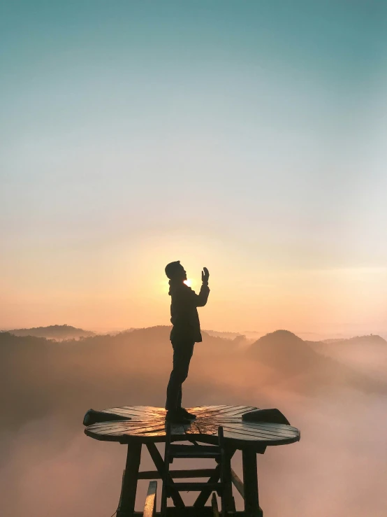 a man standing on top of a wooden table