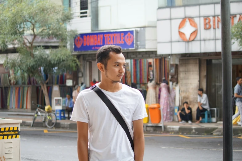 a man standing on a street corner with a traffic light