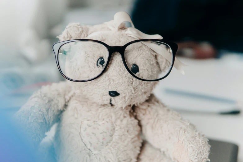 a small white teddy bear wearing a pair of glasses
