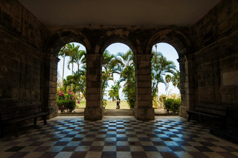 a beautiful tiled floor with columns and benches