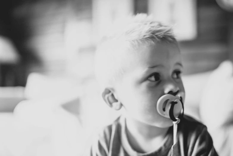 a little boy with a pacifier in his mouth