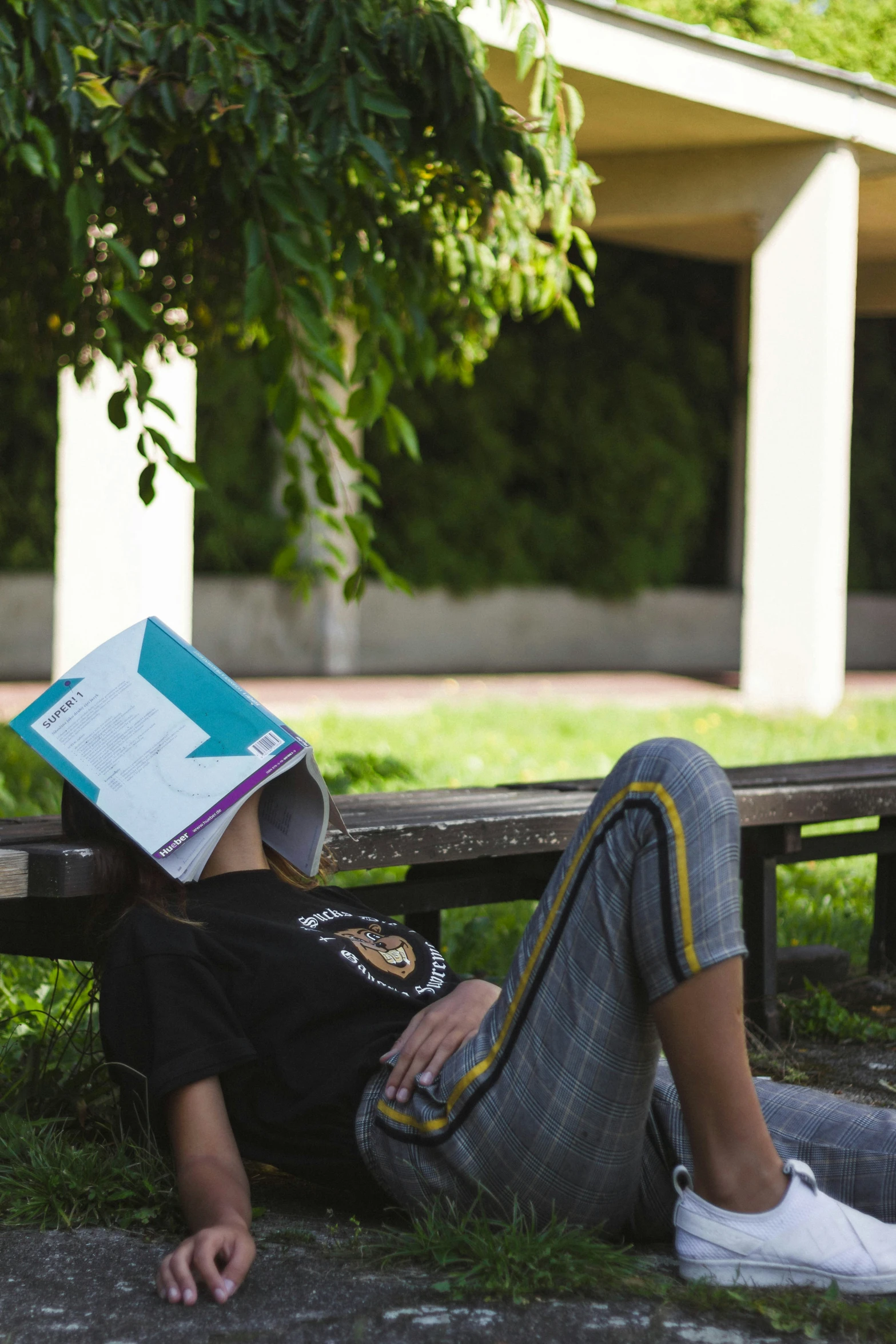 a young man sitting on a bench with an open book