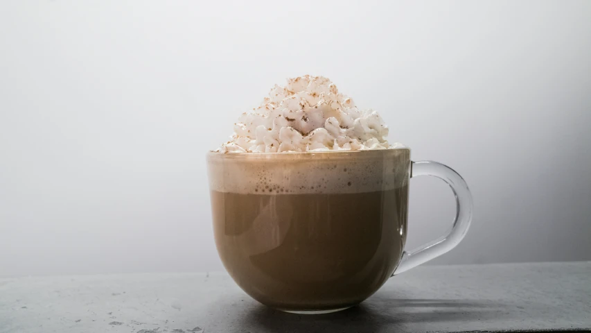 a cup of coffee on a table with marshmallows