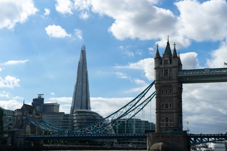 a large suspension bridge with the shard of tower visible