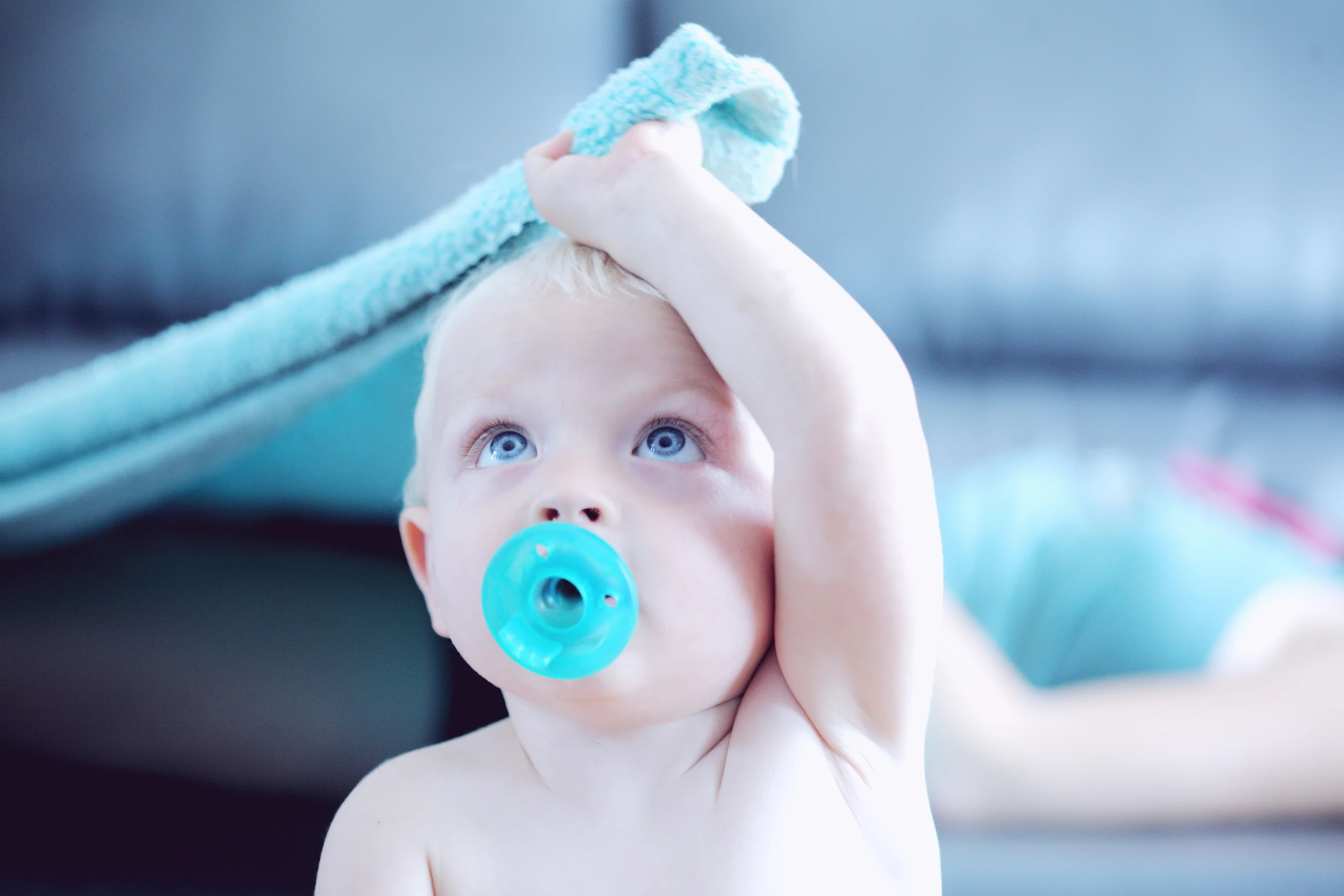 a baby girl with her hands on a brush in a room