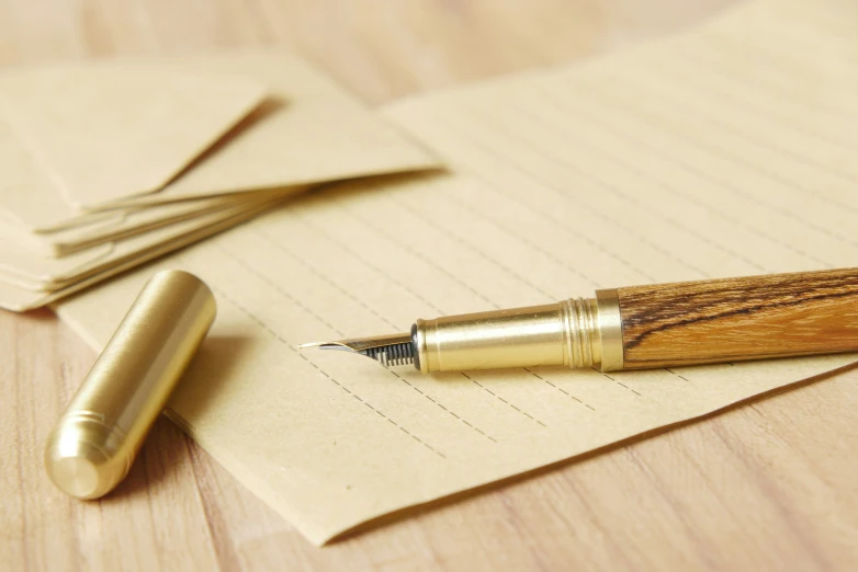 a pen sitting on top of a piece of paper next to a pencil