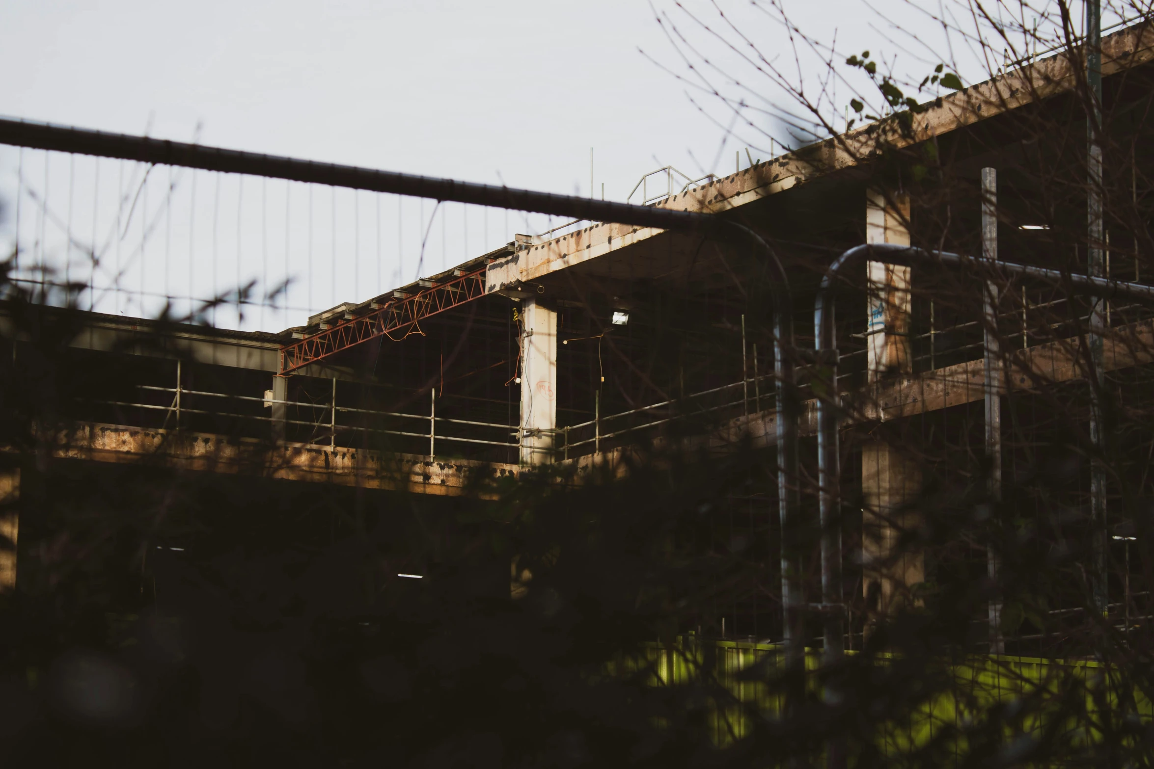 a bridge with a wire railing and trees