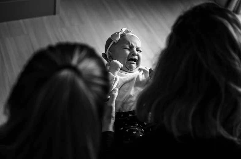 mother showing her infant a bath of his own hair