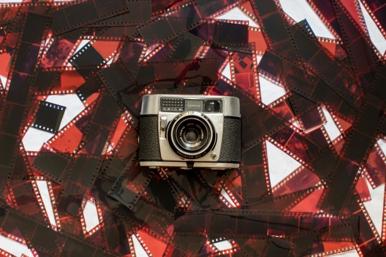 a camera is lying on some red and white sheets