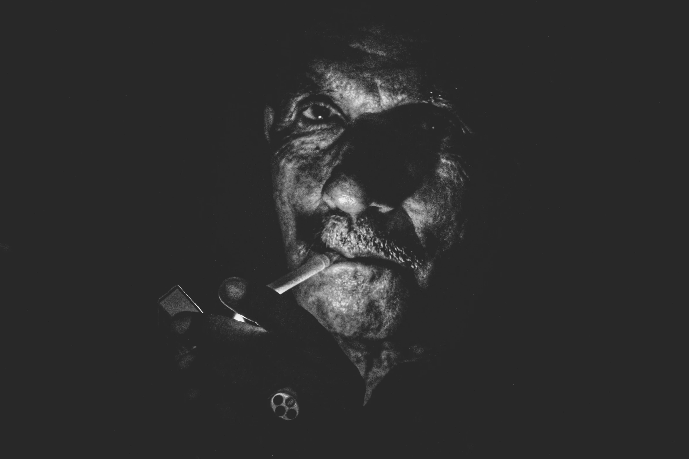 the man is smoking a cigar in the dark