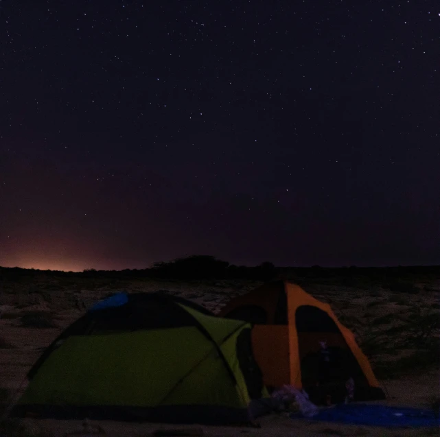 a tent in the dark near stars above