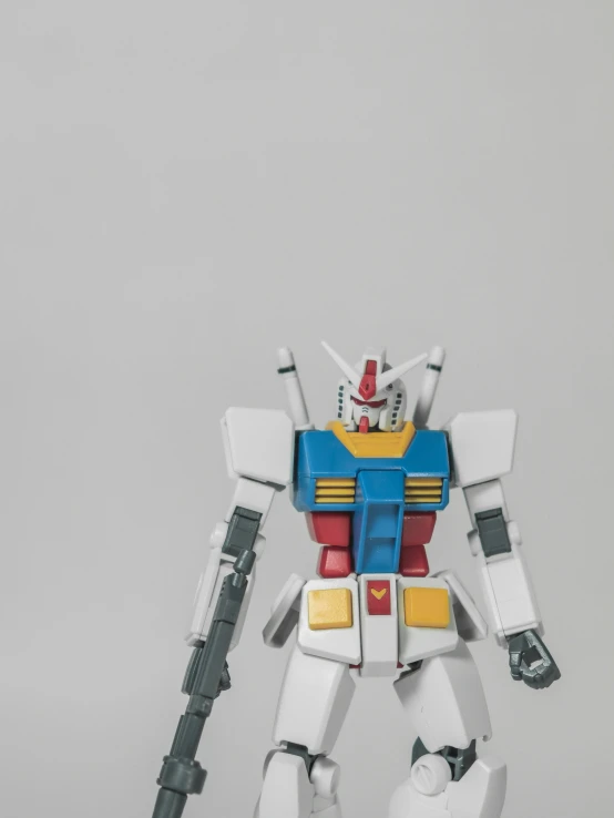 a white robot action figure that is holding a rifle