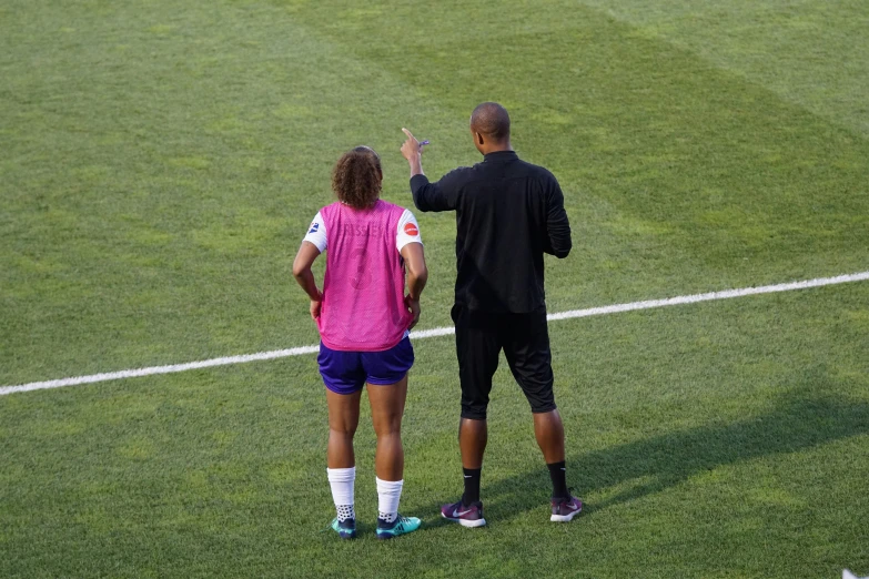 a man and woman high five on a field