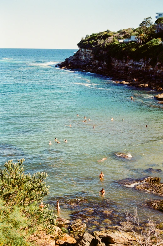 people in the water at the beach on a sunny day