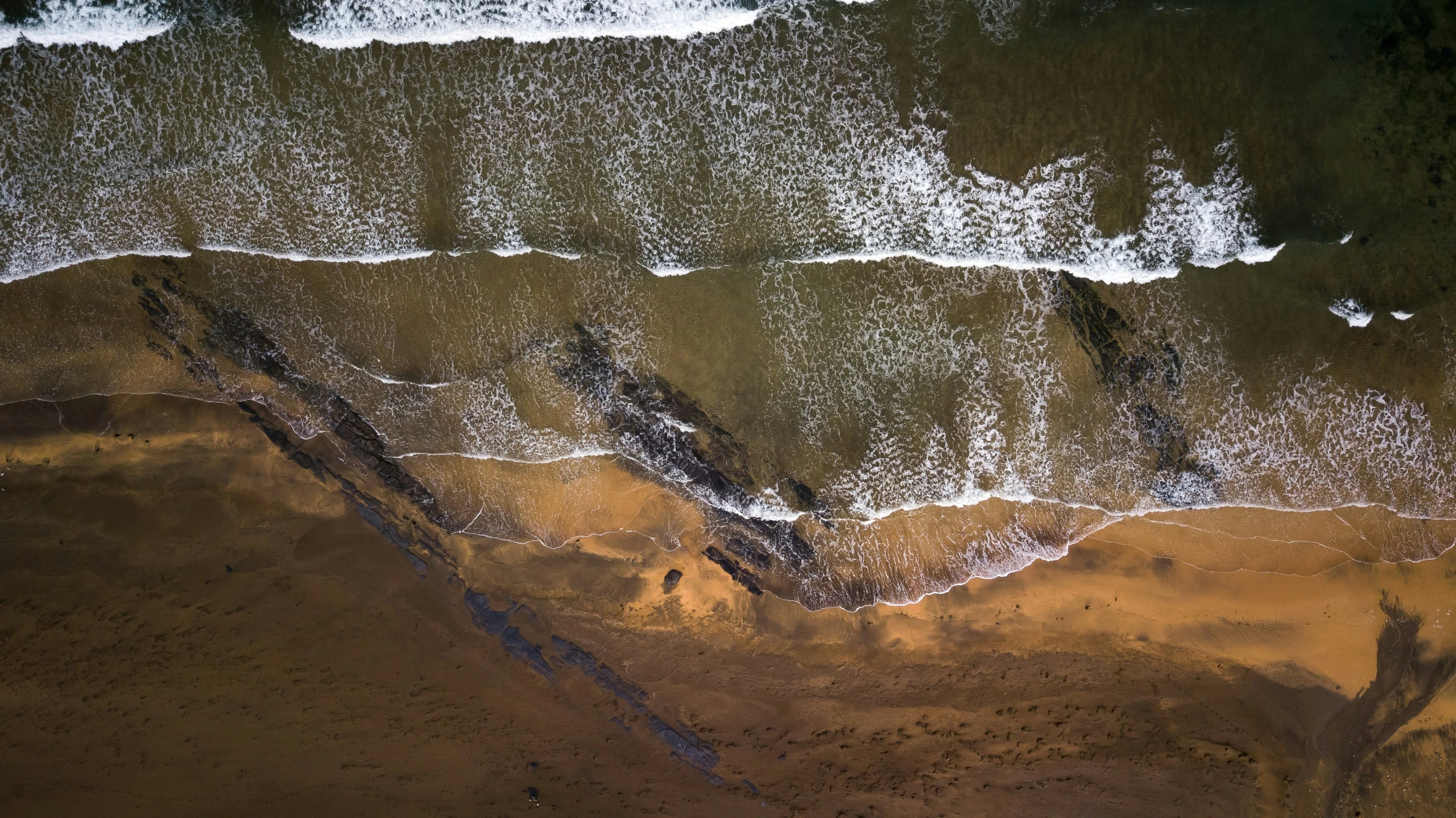 a water scene of a river running into a sandy beach