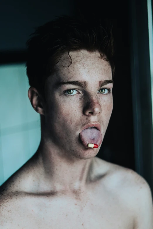 a shirtless young man is holding up a stick in his mouth