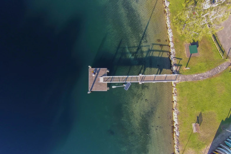 the water is blue and there are people standing at the pier