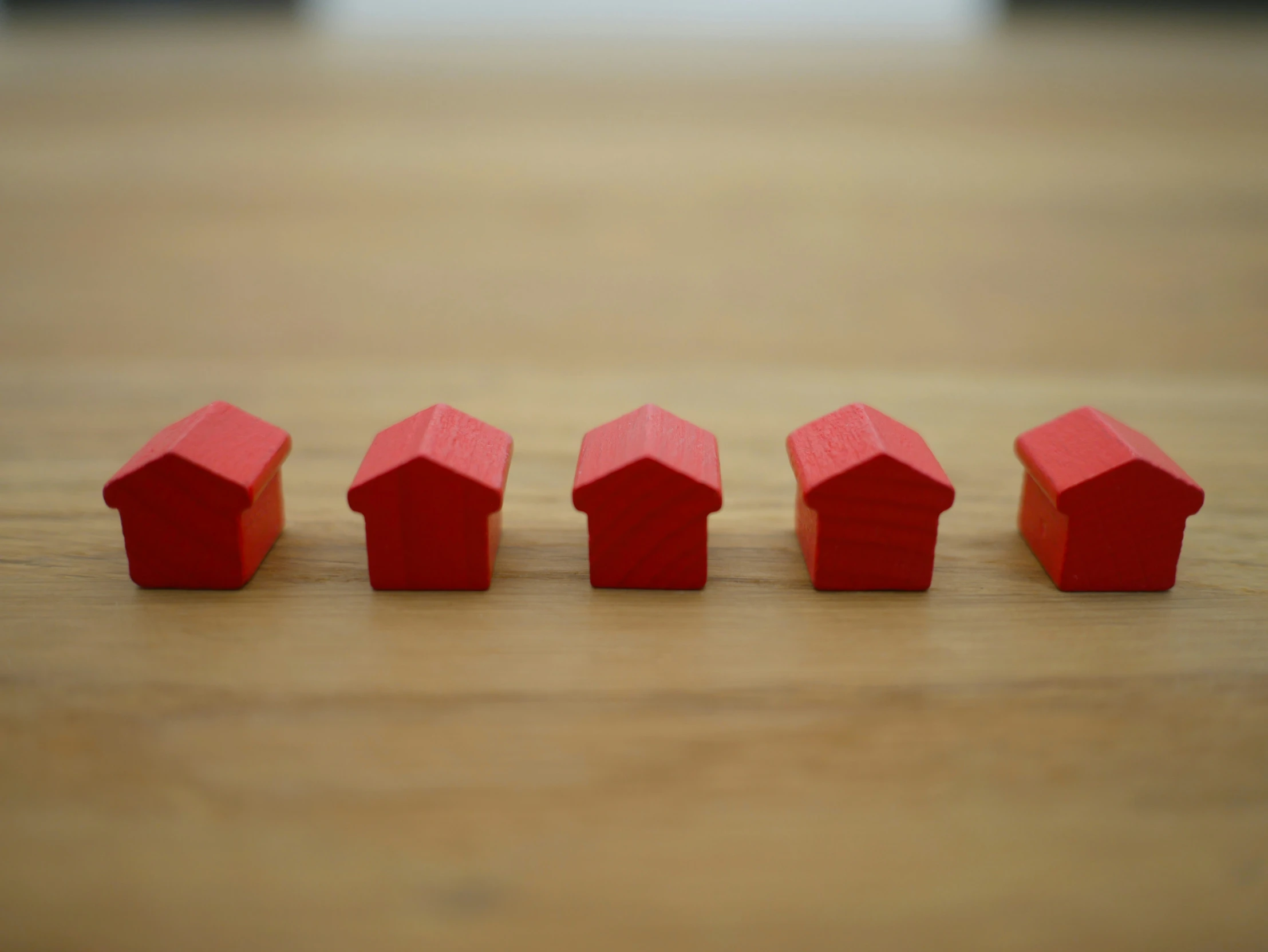 four red houses with the roof turned down on a wood table