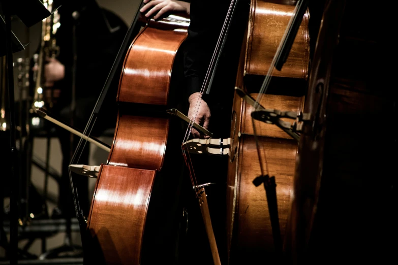 someone is playing a cello with a man behind