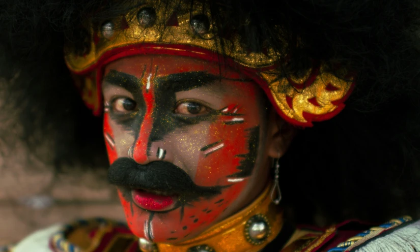 a man with a red face painted like a queen