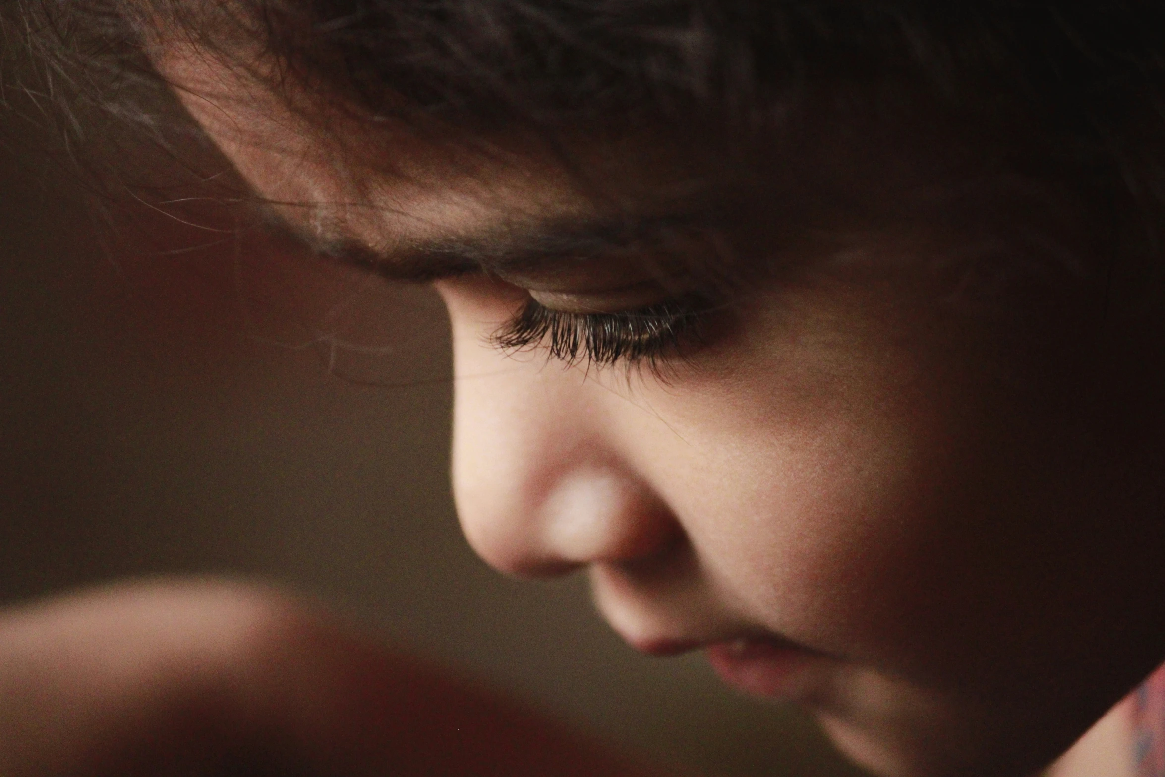 a close - up of a person with her eyes closed looking into the distance