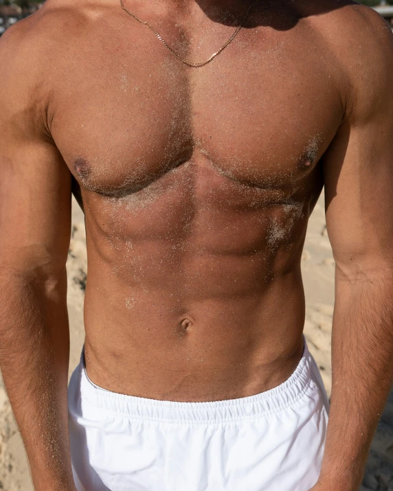 a man in boxers stands on a beach