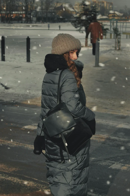 a woman wearing a jacket and hat in a winter snow storm