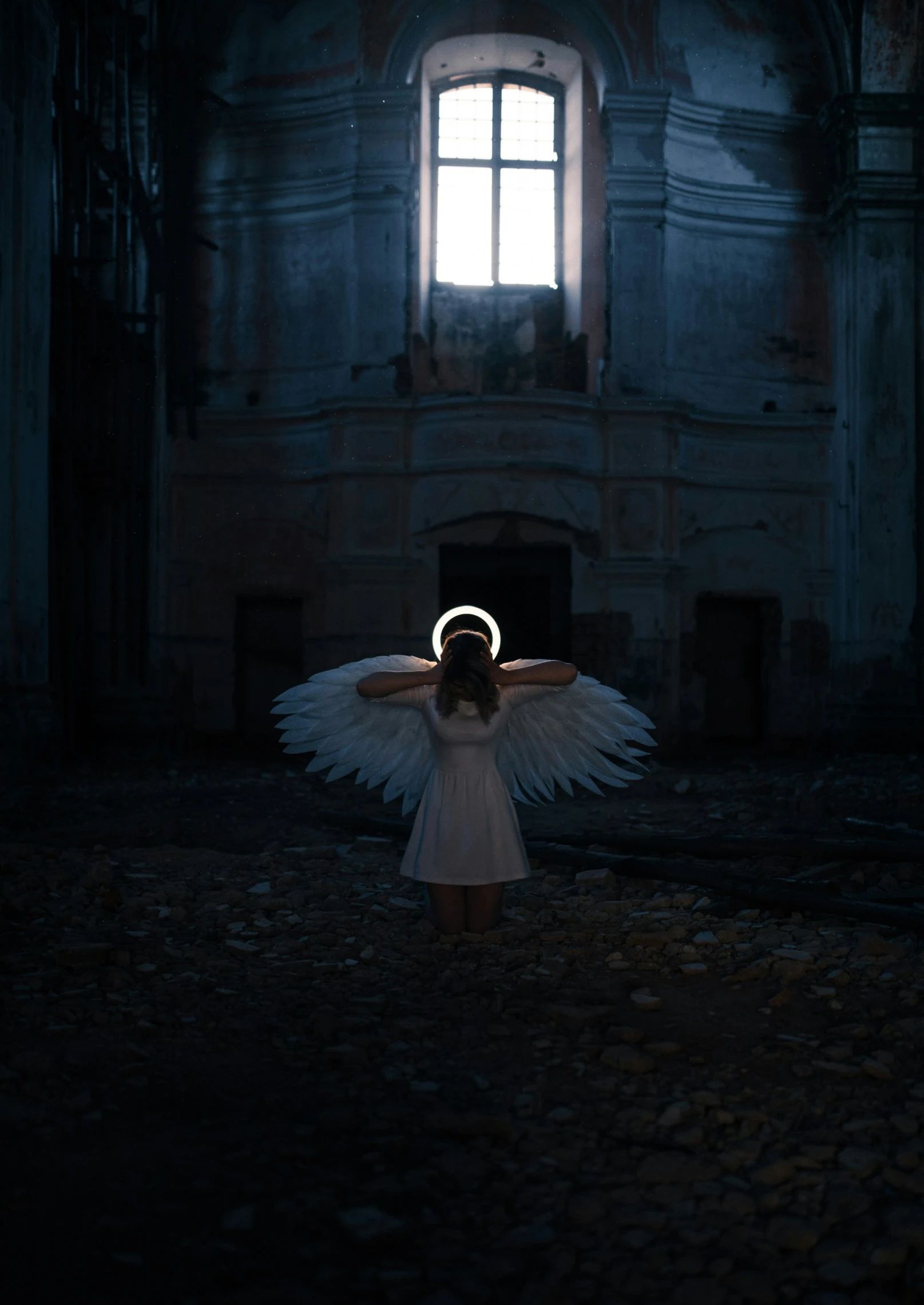 an angel standing alone with its wings open in the dark