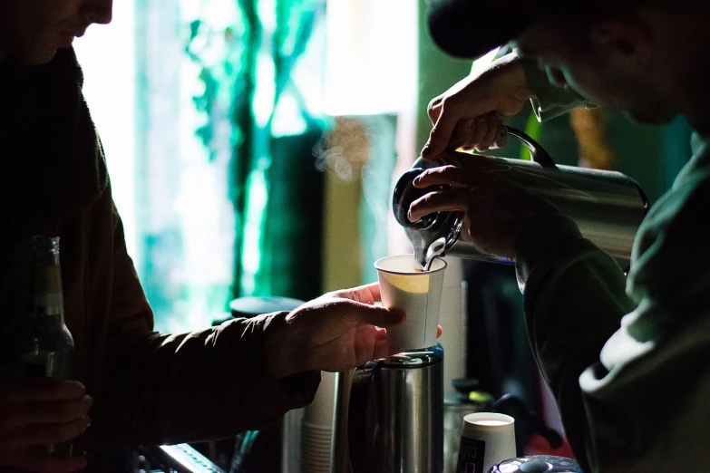 two people at a counter preparing a drink