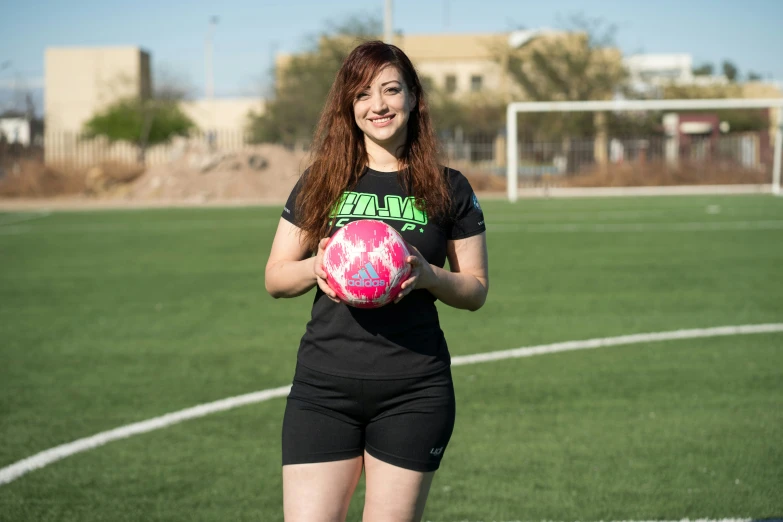 woman holding a ball and smiling while posing for picture