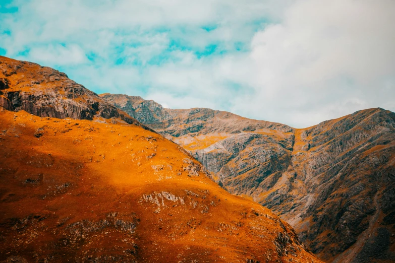 a hill covered in lots of brown grass and rocks